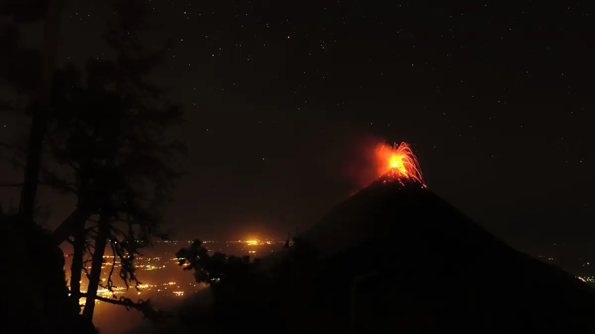 Der Fuego bei Nacht vom östlichen Lagerplatz am Acatenango, unten die Lichter des Tals