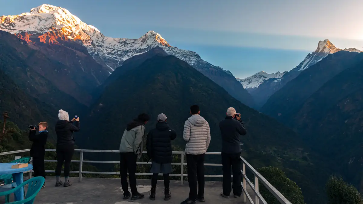 Trekkers on the viewing terrace in Chhomrong with Annapurna South and Hiunchuli