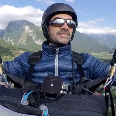 Kai-Michael Rauch paragliding above an Alpine valley