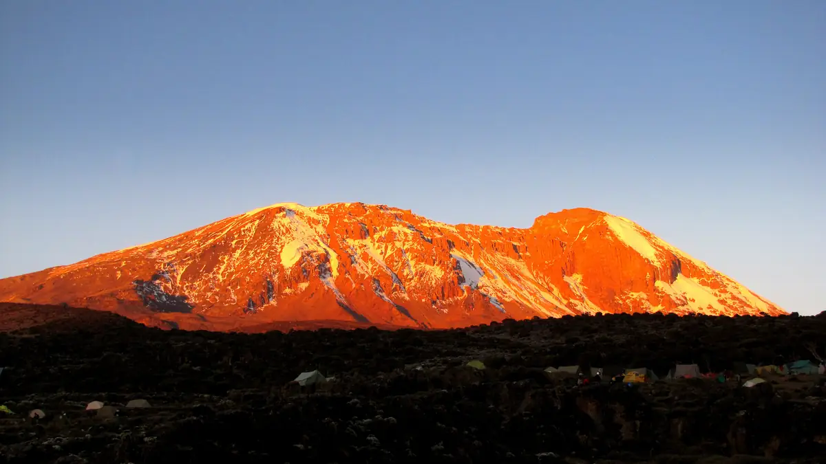 Kibo in the evening glow above a tent camp