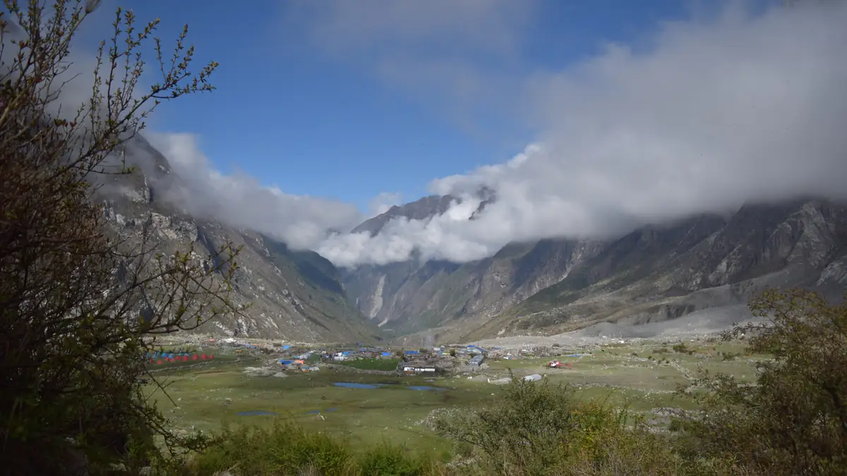 Lodges on the valley meadow, cloud rising up the slope
