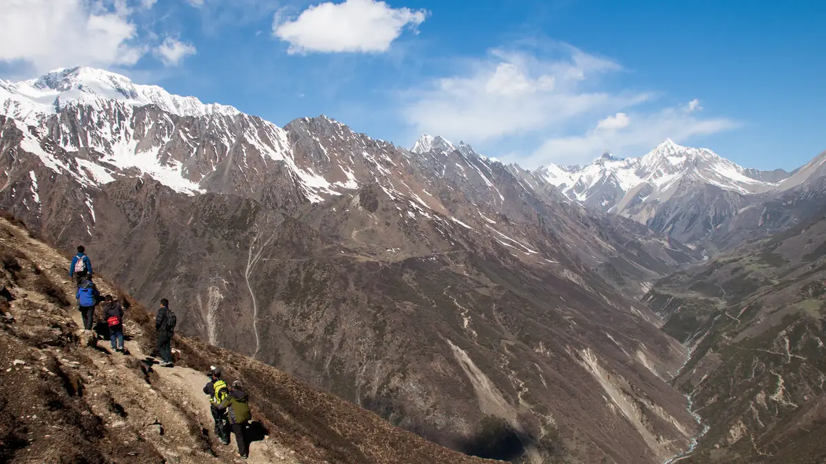 Wanderer am Hang im Tsum Valley, das Tal weit unten