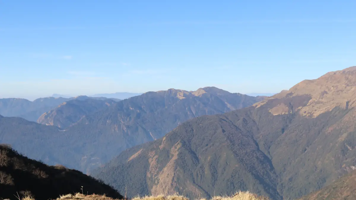 High Camp auf dem Kamm, 3.580 Meter: Lodges mit blauen Dächern, dahinter die Hügel bis Pokhara