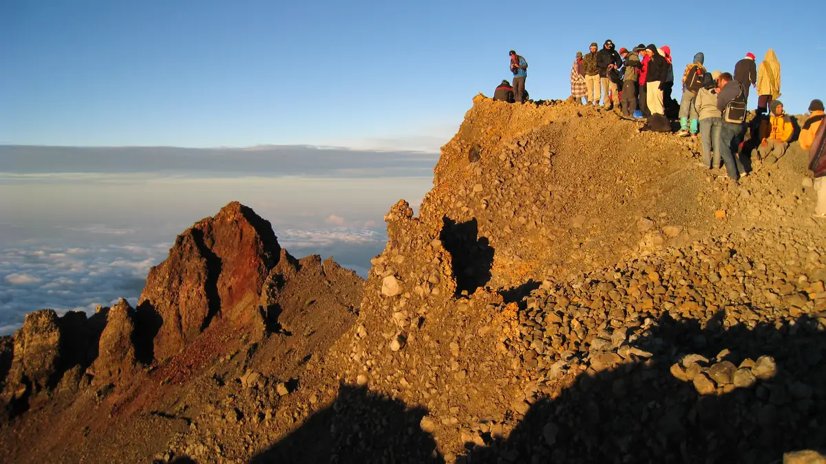 Trekker auf dem Gipfel des Rinjani bei Sonnenaufgang