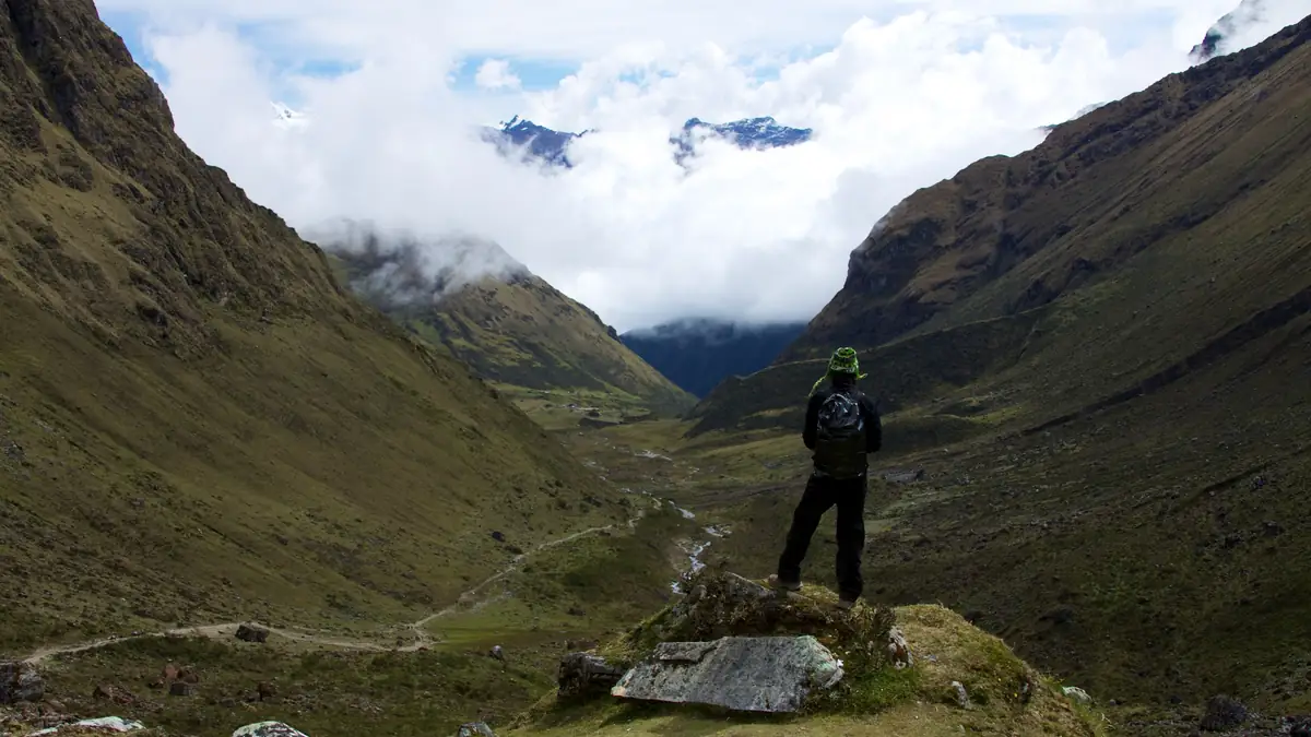Hiker at Abra Salkantay looking back down the Soraypampa valley