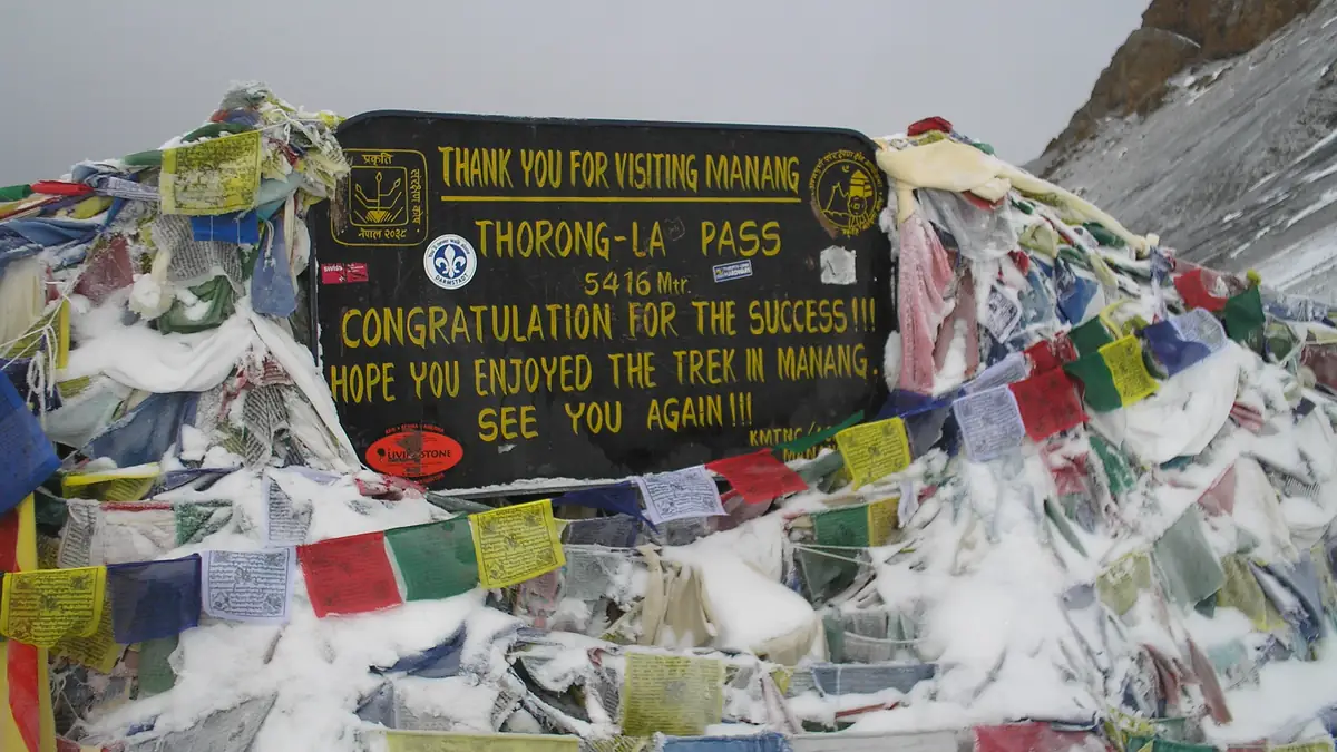 The sign on Thorong La with prayer flags: 5,416 m