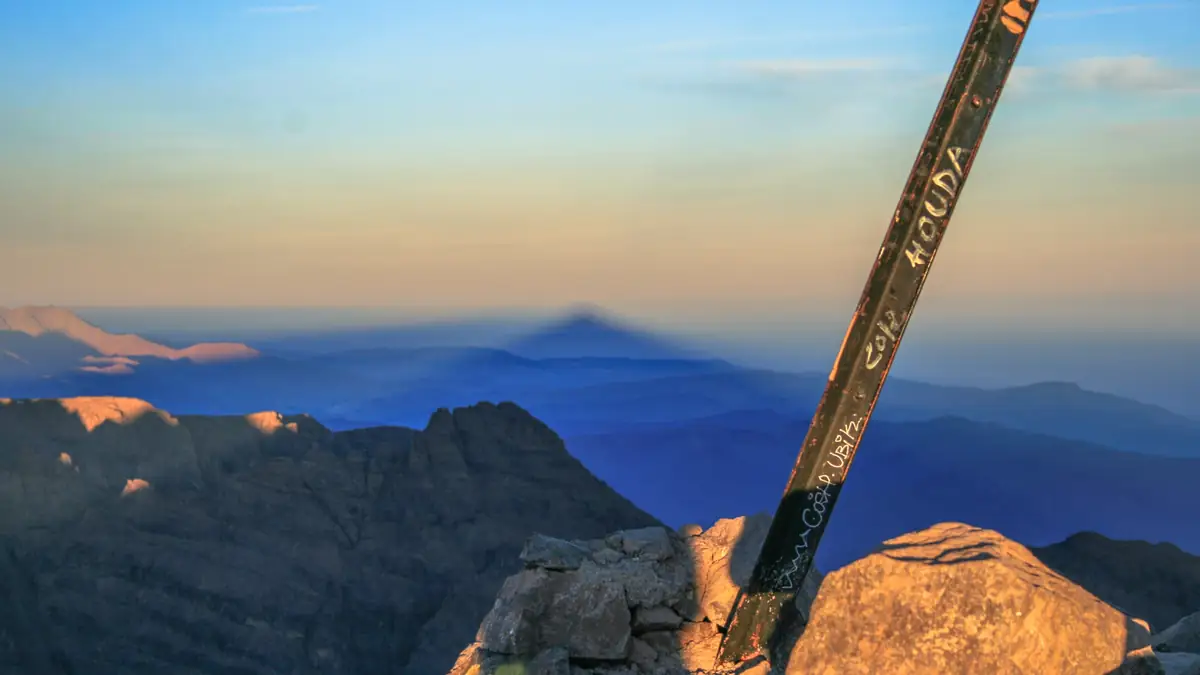 Der Schatten des Toubkal liegt bei Sonnenaufgang als Dreieck über dem Hohen Atlas