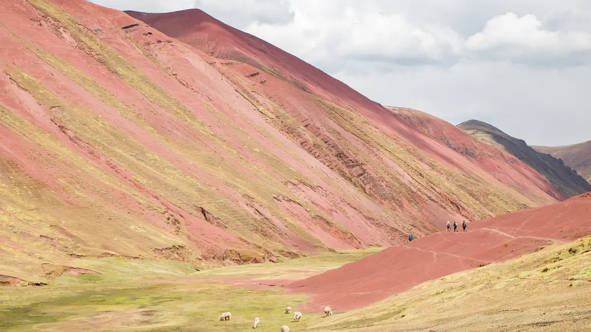 The Red Valley: red slopes, hikers and alpacas on the valley floor