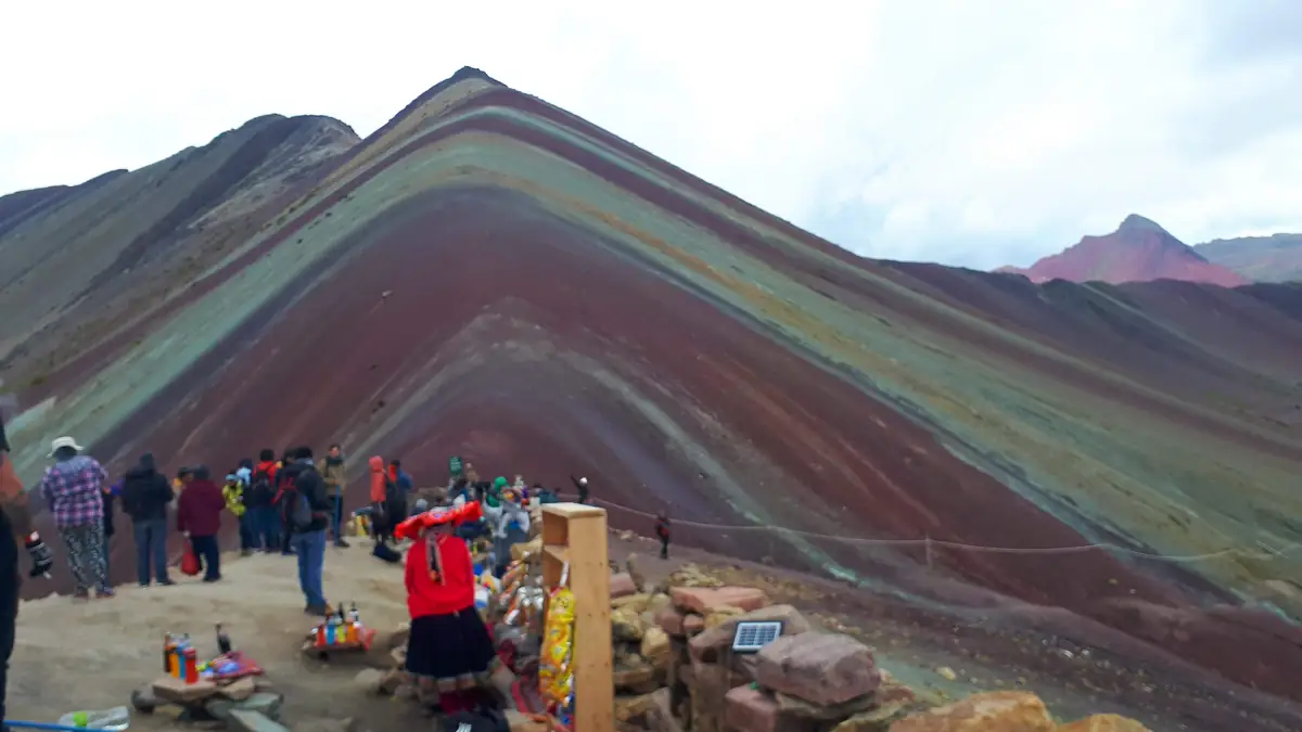 Andrang am Aussichtspunkt des Vinicunca am Vormittag: Verkaufsstände, Fotografen, Gruppen